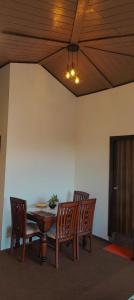 a dining room with a table and chairs and a ceiling at Alan's 3BHK in Nainital