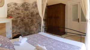 a bedroom with a bed and a stone wall at Villa Il Casale Onifai in Onifai