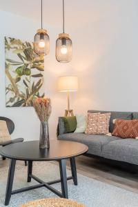 a living room with a couch and a table at Charming apartment with parking and balcony. in La Madeleine