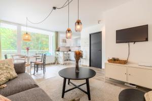 a living room with a couch and a table at Charming apartment with parking and balcony. in La Madeleine +21 photos