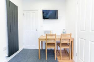 a dining room with a table and a tv on a wall at Urban Oasis Hideaway in Birmingham