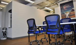 einen Konferenzraum mit blauen Stühlen und einem Tisch in der Unterkunft Cosmos capsule coworking London in London