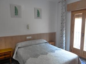 a bedroom with a bed and a window at Apartamentos Casa FERMINA - A 2 horas de las pistas de esquí in Trevélez