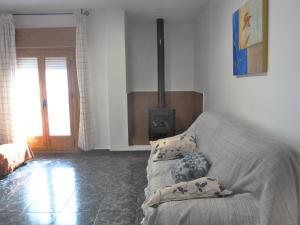 een woonkamer met een bank en een open haard bij Apartamentos Casa FERMINA - A 2 horas de las pistas de esquí in Trevélez