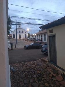 a parking lot with a car parked in front of a church at Casa Colonial. Centro Histórico in Paracatu