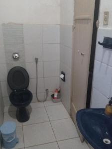 a bathroom with a black toilet and a sink at Casa Colonial. Centro Histórico in Paracatu
