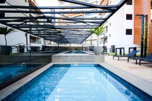 a swimming pool in a building with a building at Nun Apartments by BnbHost in Sao Paulo