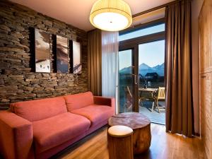 uma sala de estar com um sofá e uma parede de pedra em Natur Resort em Veľká Lomnica