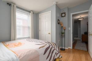 a bedroom with a bed and a large window at Johns Hopkins Historic Renovated home - Fells Point! in Baltimore