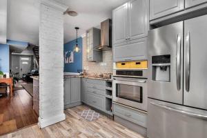 a kitchen with stainless steel appliances and blue walls at Johns Hopkins Historic Renovated home - Fells Point! in Baltimore