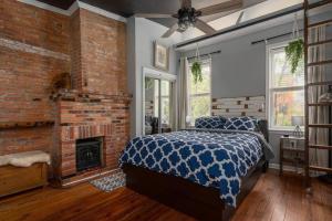a bedroom with a bed and a brick fireplace at Johns Hopkins Historic Renovated home - Fells Point! in Baltimore