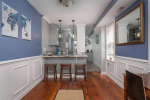 a kitchen with blue walls and a counter with stools at Johns Hopkins Historic Renovated home - Fells Point! in Baltimore