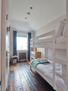 a bedroom with two bunk beds and a window at Two Rows Back From the Sea in Deal