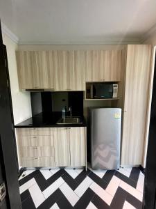 ジョムティエンビーチにあるLuxury stay Venetian signatureのキッチン(木製キャビネット、冷蔵庫付)