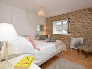 a bedroom with two beds and a table with a lamp at 3 Bed in Burton Bradstock DC055 in Burton Bradstock