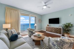 ein Wohnzimmer mit Sofa und Fernseher in der Unterkunft Sterling Breeze 1003 in Panama City Beach