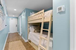 ein kleines Schlafzimmer mit einem Etagenbett und blauen Wänden in der Unterkunft Sterling Breeze 1003 in Panama City Beach + 35 Fotos