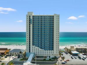 ein hohes Gebäude neben einem Strand mit Blick auf das Meer in der Unterkunft Sterling Breeze 1003 in Panama City Beach