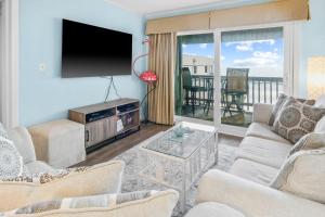 uma sala de estar com uma televisão de ecrã plano e uma varanda em Almost Heaven em Myrtle Beach