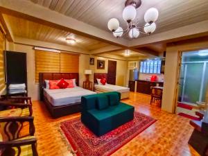 a bedroom with a bed and a couch and a tv at Monte Rio Gardens Bed & Breakfast in Alaminos