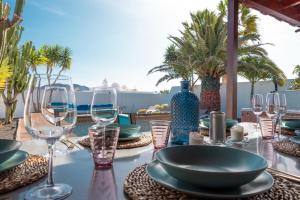 een tafel met borden en wijnglazen op een patio bij Villa Angelita in Playa Blanca