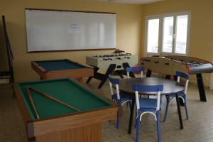 uma sala de aula com mesas de bilhar e cadeiras e um quadro branco em Appart en front de mer pour famille : Molène em La Bernerie-en-Retz