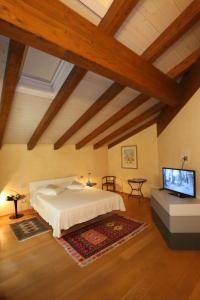 a bedroom with a bed and a flat screen tv at A Casa di Maria in Grinzane Cavour