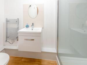 een witte badkamer met een wastafel en een douche bij 3 Bed in Burley 80475 in Burley