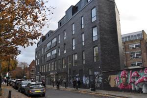 a building with graffiti on the side of it on a street at Cosmos capsule coworking London in London