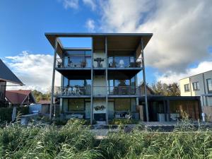 een huis met een groot balkon met een terras bij B&B Veluwemeer in Biddinghuizen