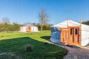 a yurt and a building in a field with a yard at Le Village des Templiers in Trie-Château