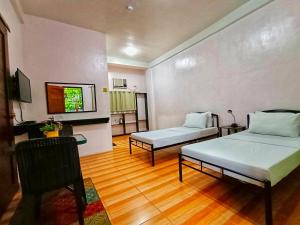 a room with two beds and a kitchen in it at Monte Rio Gardens Bed & Breakfast in Alaminos