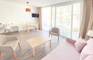 ein Wohnzimmer mit einem Sofa und einem Tisch in der Unterkunft Apartamentos Morito Beach in Cala Millor