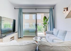 a living room with a couch and a tv at Apt Ca na Claire in Port de Pollensa
