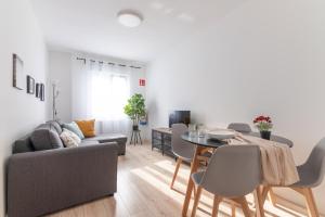 uma sala de estar com um sofá e uma mesa em Tetuan street apartment em Santander