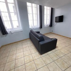 a black couch in a living room with windows at Thubaneau St Charles Canebière Vieux port in Marseille
