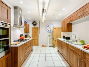 a kitchen with wooden cabinets and white tile floors at 2 Bed in Appledore 63084 in Appledore