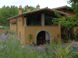 een huis met een tuin met paarse bloemen bij Can Japet in Santa Llogaia del Terri