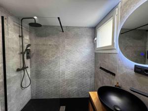 La salle de bains est pourvue d'une douche et d'un lavabo noir. dans l'établissement La Plaza del Pilar, à Saragosse