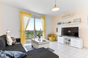 un soggiorno con divano e TV di Sunny View - A Stunning Apartment With Private Rooftop a Paphos