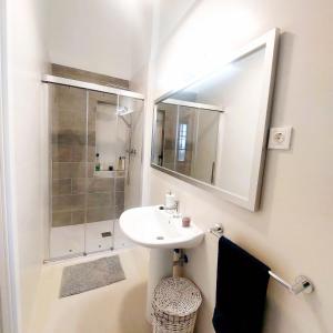 La salle de bains blanche est pourvue d'un lavabo et d'une douche. dans l'établissement Casa Vacaciones ALMADRABA CABO COPE, à Águilas