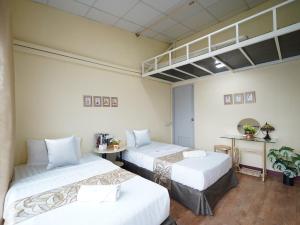 曼谷的住宿－EZ Sleep @ Ratchada 19，一间设有两张床和一张桌子的房间