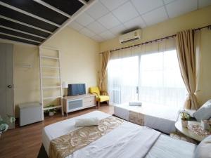 a hotel room with two beds and a window at EZ Sleep @ Ratchada 19 in Bangkok