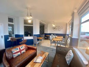 a living room with a couch and tables and chairs at The Fossil Tree Hotel in Blackpool