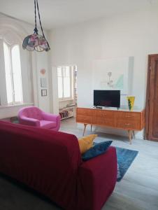- un salon avec un canapé rouge et une télévision dans l'établissement L'Appartamento Storico dal Design Moderno, à Faenza