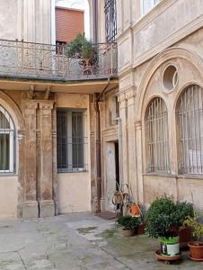 un ancien bâtiment avec un balcon et des plantes en pot dans l'établissement L'Appartamento Storico dal Design Moderno, à Faenza