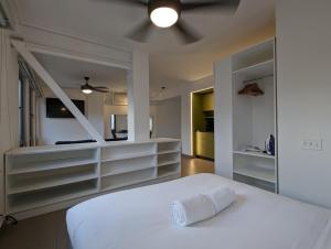 een slaapkamer met een wit bed met een handdoek erop bij Casa Ambar Apartments in Panama-Stad