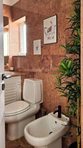 La salle de bains est pourvue de toilettes blanches et d'un lavabo. dans l'établissement Sweet Formosa View, à Faro