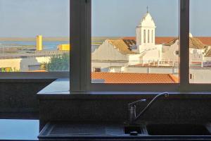a kitchen sink with a view of a church at Sweet Formosa View in Faro