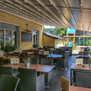 um restaurante vazio com mesas, cadeiras e mesa em TOUCH DOWN Motel em Lohmar